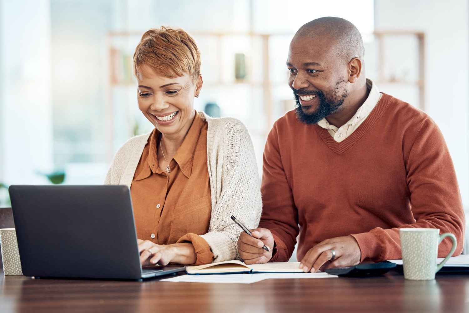 Homem sentado com uma mulher de frente para um computador